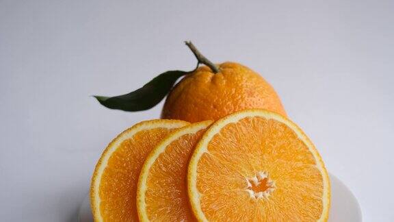 成熟多汁的橙子新鲜切好的橙子背景是带叶子的橙子