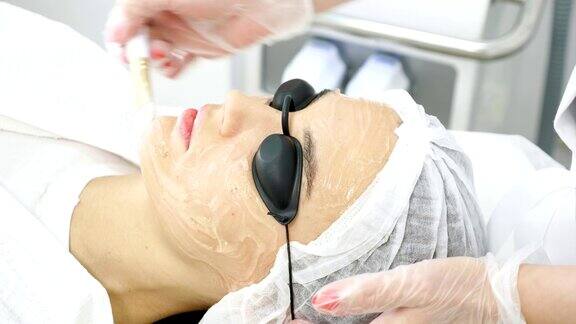 治疗师在女性病人脸上涂抹特殊软膏