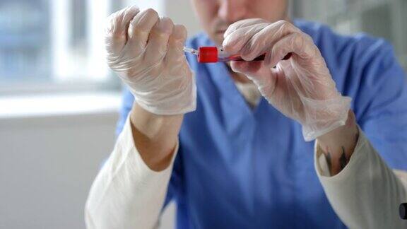 实验室工作人员用注射器从试管中抽血