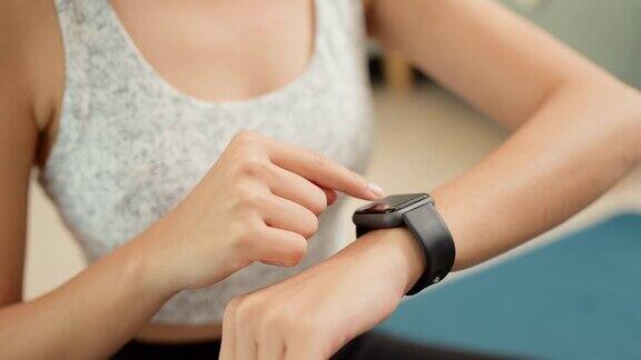 体育亚洲妇女看智能手表心率监测器