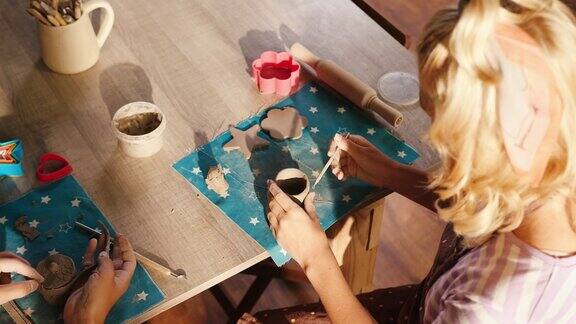 十几岁的女孩坐在教室的桌子上雕刻粘土杯子