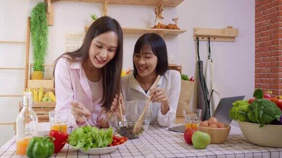 两个亚洲妇女在厨房做沙拉健康蔬菜烹饪