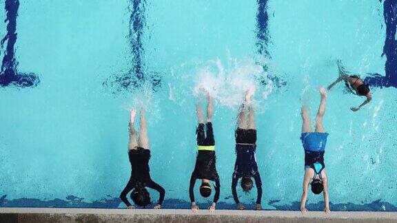 在游泳教练的指导下亚洲中国游泳运动员在泳池边练习用腿泼水