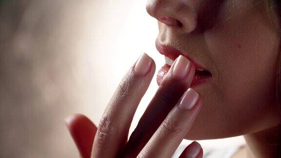 唇护理女人用手指触摸柔软的嘴唇特写