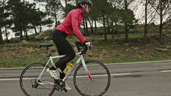 成熟的西班牙女性铁人三项运动员训练赛车自行车