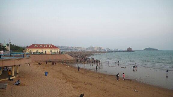 日落天空青岛海岸线著名的拥挤公共海滩全景4k中国
