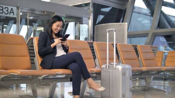 女商人在机场使用手机