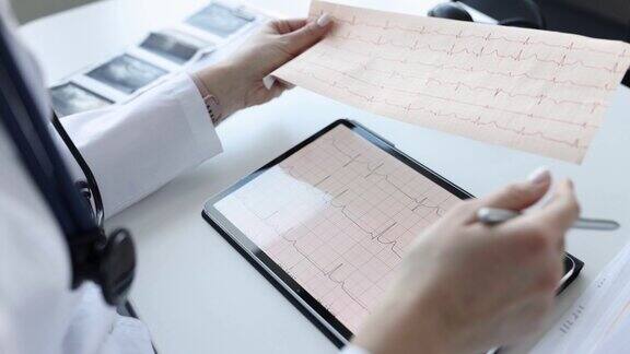 心脏病专家在平板上检查病人的心电图