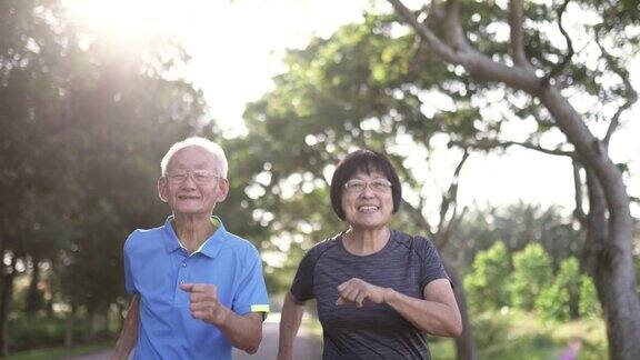 2对亚洲华人老年夫妇早上在公园慢跑