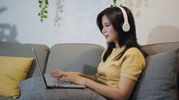 视频肖像的年轻成年亚洲女性自由职业者使用笔记本电脑在线工作在家女性与同事进行视频会议而远程工作在家里