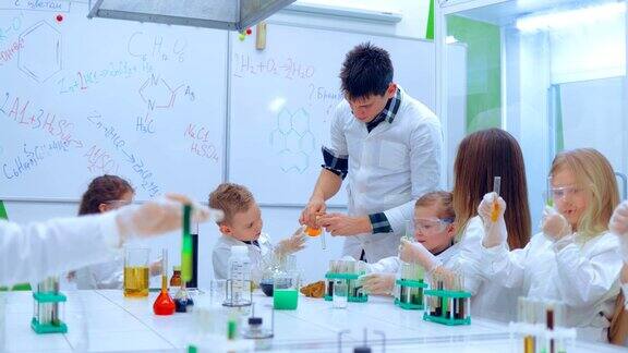 学生和老师在科学课上观看实验教育、儿童、科学和概念