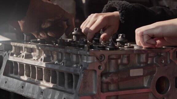 机械师用手修理汽车发动机气门盖螺丝