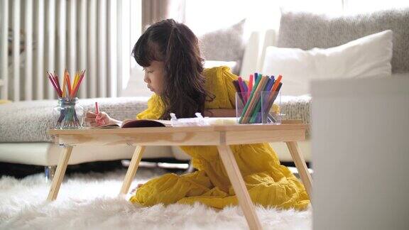 小女孩周末在家客厅画作业