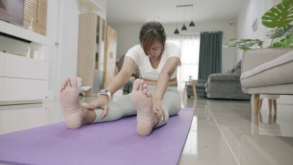 年轻的亚洲女人在家练习瑜伽的场景
