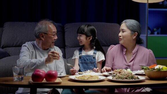 亚洲人幸福的家庭在餐桌上吃午餐日本人在一起微笑小孩子女儿喜欢吃爷爷奶奶的食物幸福时光人们的生活方式观念