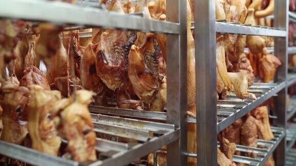 在肉类加工厂的储藏室里挂在架子上的熏鸡