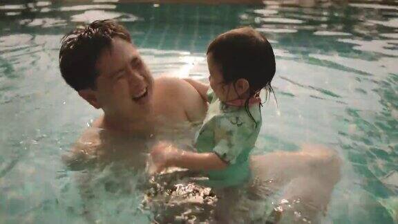 爸爸和女儿在游泳池里游泳