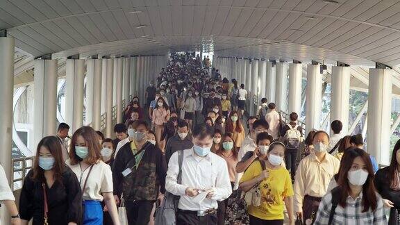 4K分辨率的亚洲人群在早高峰时间在曼谷上班时戴着防冠状病毒或新冠病毒防护面罩和空气中的微尘pm2.5