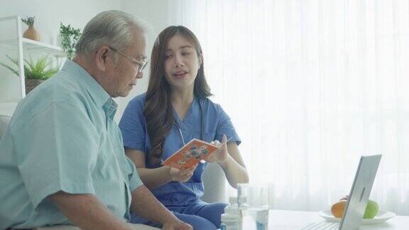 家庭保健东南亚老年人护理护士或理疗师向护理中的老年病人解释治疗的医疗计划