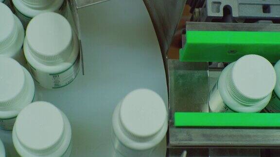 现代制药生产带药品的塑料瓶沿着传送带移动到分拣滚筒从above.close-up