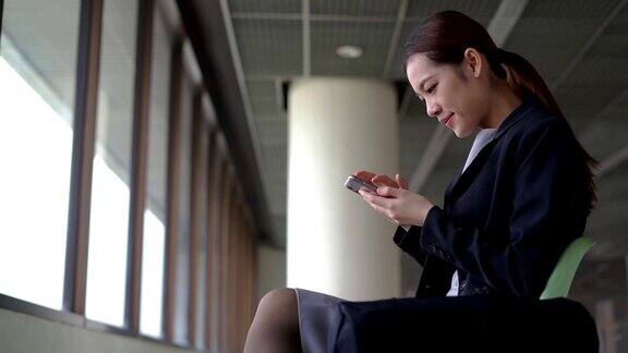 女乘客在机场用智能手机等待航空旅行