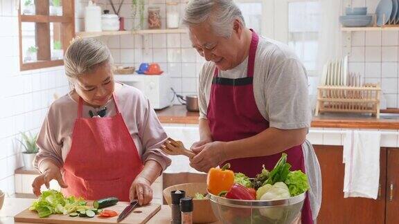 4K亚洲老夫妇一起在厨房做沙拉