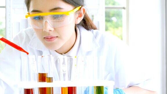 女科学家在实验室做科学实验时用吸管填充化学物质到试管中