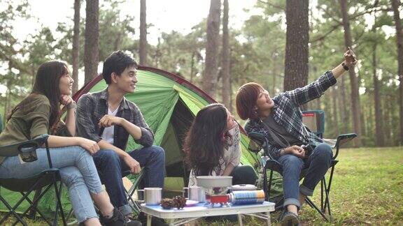 一群年轻的亚洲朋友在森林露营合影