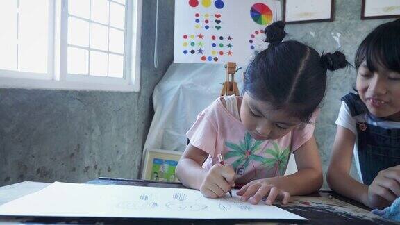 亚洲女孩在家里或小学用纸上用铅笔画画