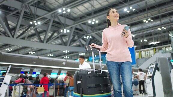 4K亚洲女子在机场航站楼使用手机