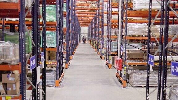 仓库-大型物流和分拣中心为零售配送货物的网络电动装载机正在接近摄像机正在向上移动