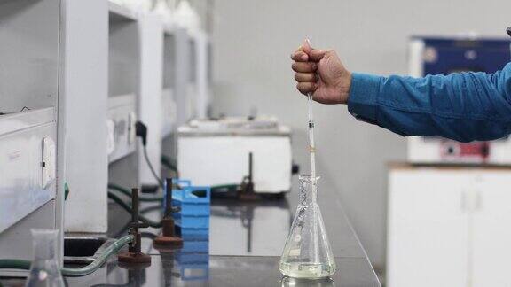 在化学实验室用玻璃移液管从锥形烧瓶中手动抽取化学品