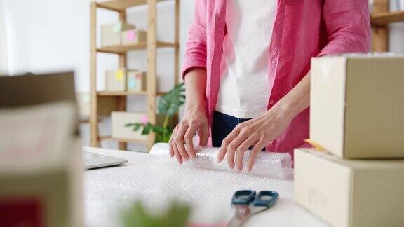 年轻的亚洲企业家女商人包装产品在纸板箱交付客户工作在家庭办公室