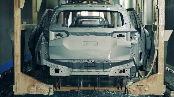 一辆车的车身底部正在用液体进行化学处理汽车制造厂汽车生产汽车生产线