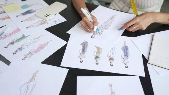 亚洲女时装设计师正在她的工作室里画画和工作