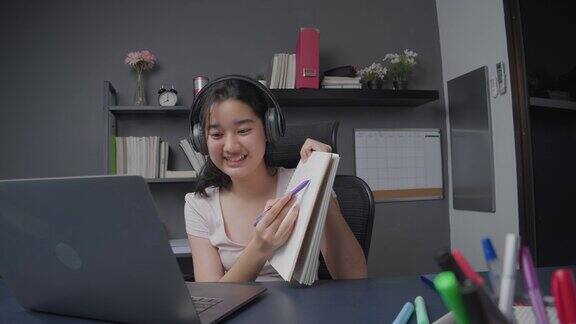 4k分辨率迷人的亚洲少女通过笔记本电脑向朋友解释数学作业在冠状病毒封锁期间她通过在线视频电话在家教授数学公式远程办公和在线学习技术