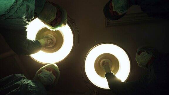 外科团队在医院手术室工作手术操作手术灯的广角视图