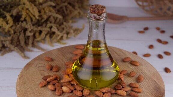 在木制背景上以杏仁坚果为背景在壶中或瓶子中加入杏仁油