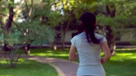 年轻的亚洲女性在城市公园跑步