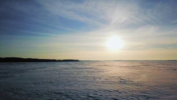 鸟瞰图的软日落在冰冻的湖面覆盖着冰雪冬季日落时美丽的蓝天