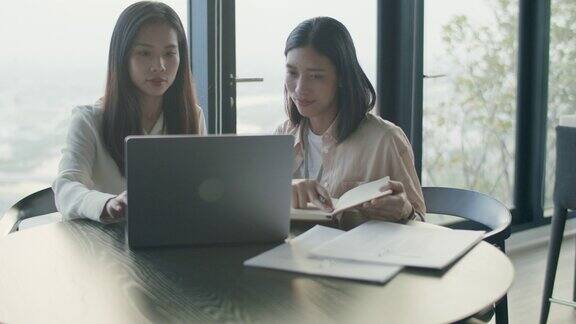 两个亚洲女商人在现代化的办公室里一起工作、讨论