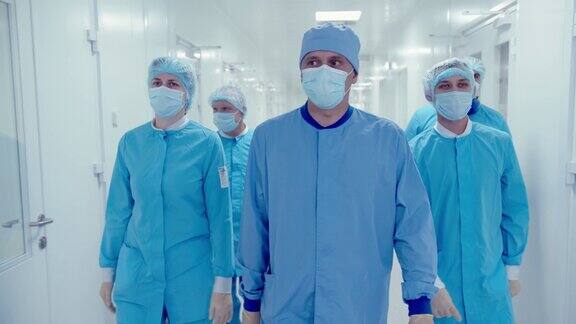 制药工人戴着防护口罩穿着医疗制服走在制药厂走廊的特写