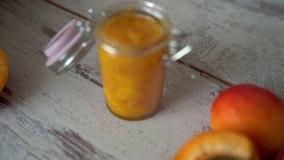 自制的杏酱装在玻璃碗里放在木桌上