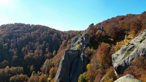 在阳光明媚的日子里茂密的山脉和岩石悬崖的秋天景观