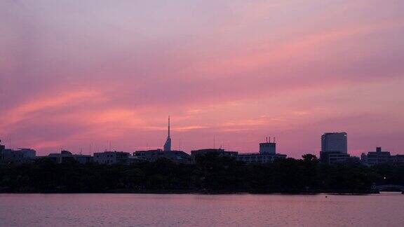 时间流逝美丽的日落倒映在湖面上的摩天大楼
