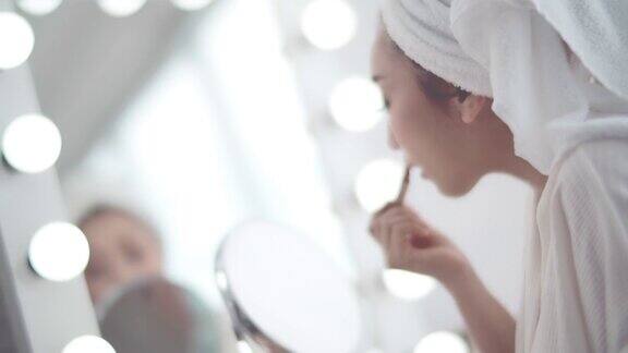 年轻妇女在镜子前化妆