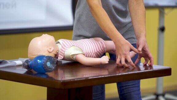 急救培训女人展示如何做心肺复苏训练的玩偶假人心肺复苏人体模型娃娃上的医学演示