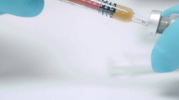在冠状病毒疫苗实验室检测期间医生使用注射器的手的特写