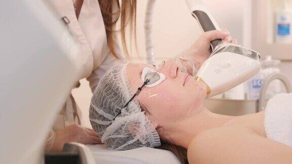 一名妇女在美容中心接受眼部周围的射频提拉手术以恢复面部皮肤的活力