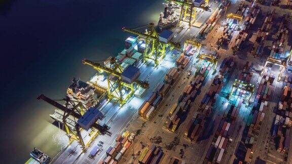 鸟瞰图无人机延时或超延时在泰国曼谷的工业港口与许多集装箱船船和大型起重机在夜间工作